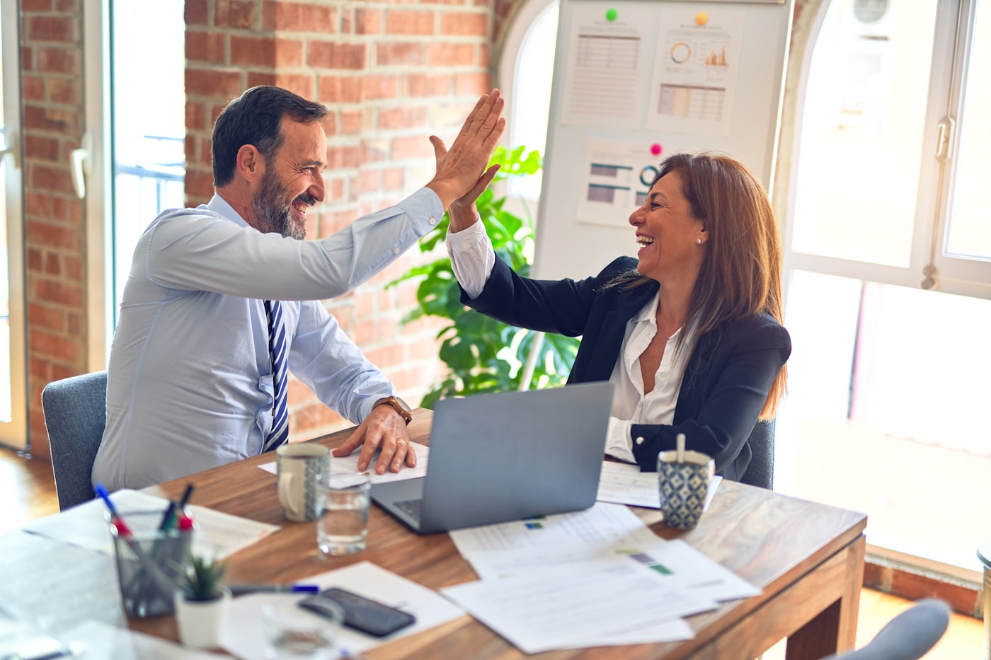 Dos consultores de GreenCanal celebrando un acuerdo con un cliente en la oficina